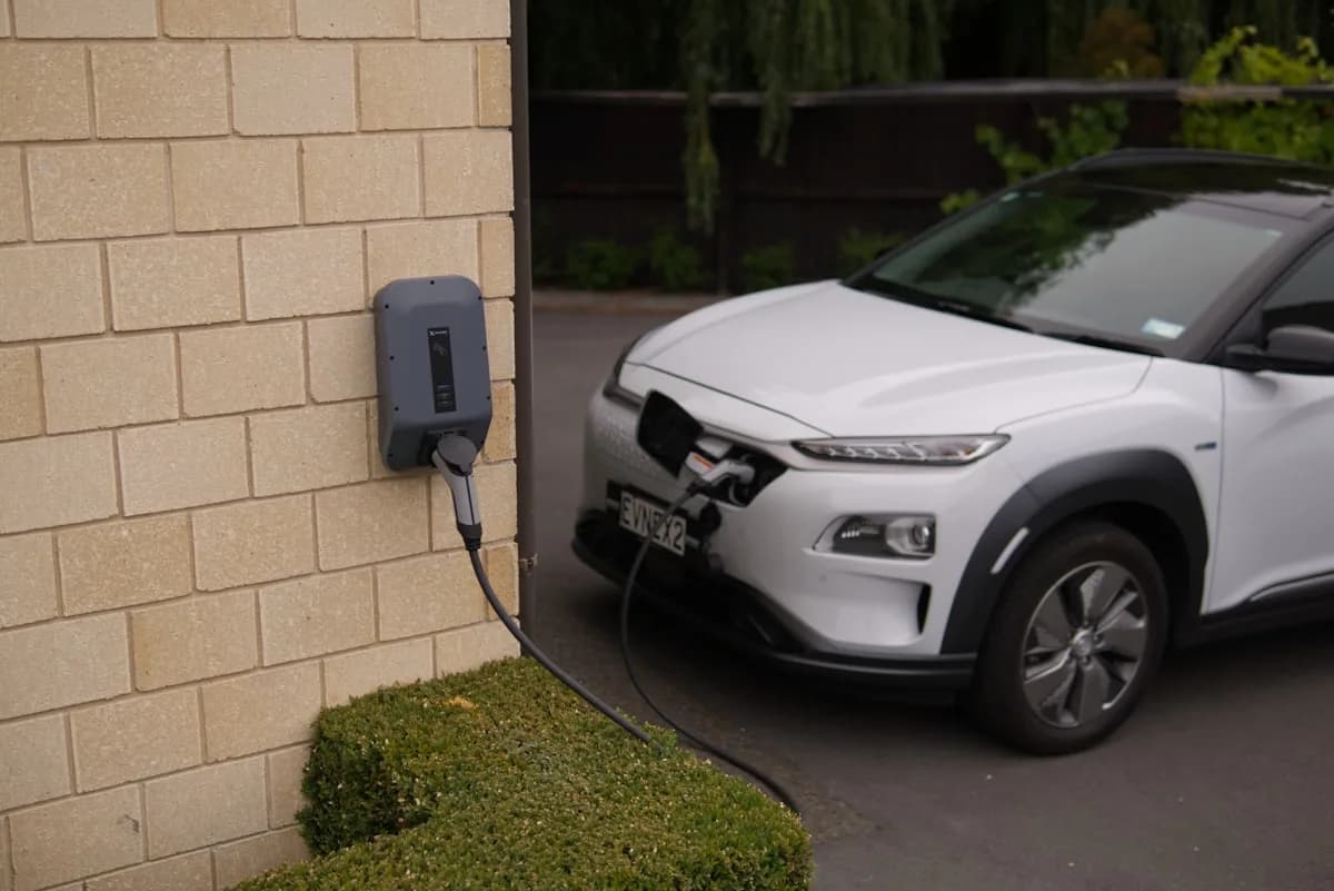 Wallbox doméstico en pared exterior cargando un coche eléctrico